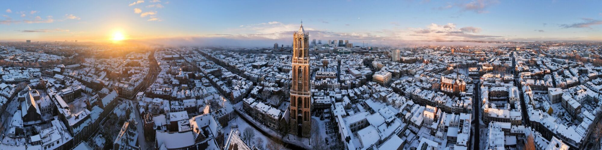 panoramic-view-of-snowy-city-at-sunrise-with-tall-tower